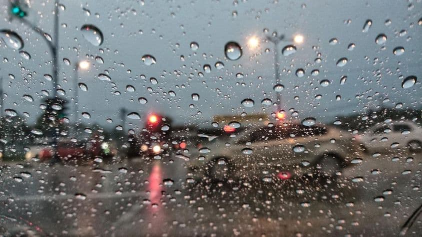 车辆透过布满雨水的玻璃显得模糊。