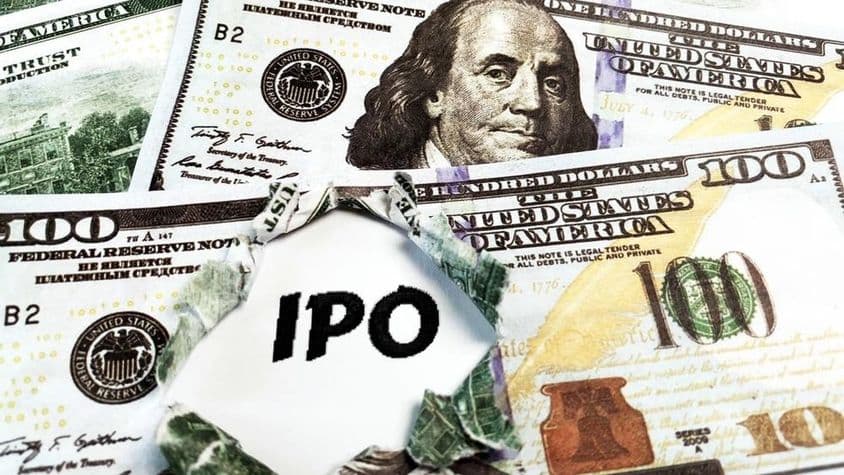一张纸上写着“IPO”,上方有美元百元钞票。
