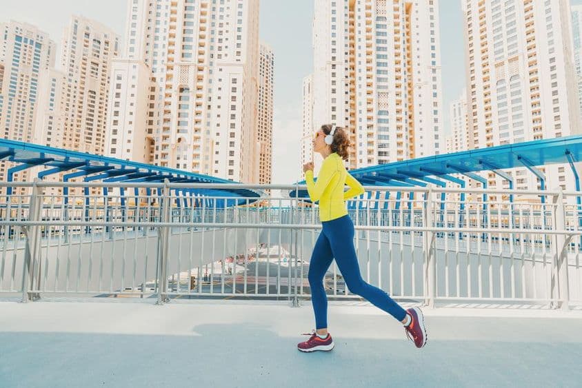 背景是摩天大楼的女性跑者