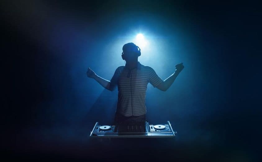 一个人站在DJ展台后面。