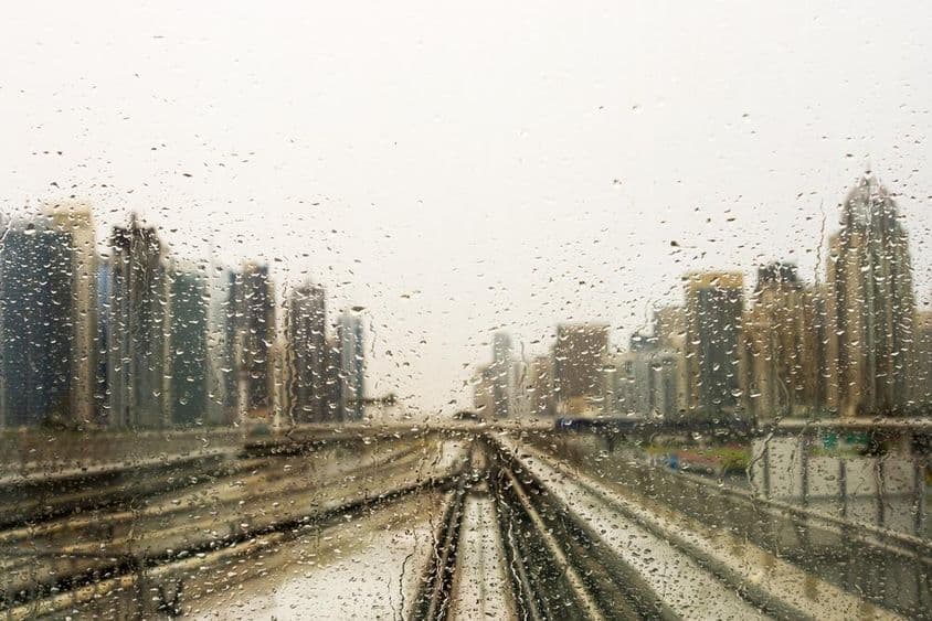 被雨水打湿的窗户外的摩天大楼景观。