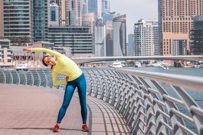 迪拜年轻女孩在马里纳跑步后拉伸。