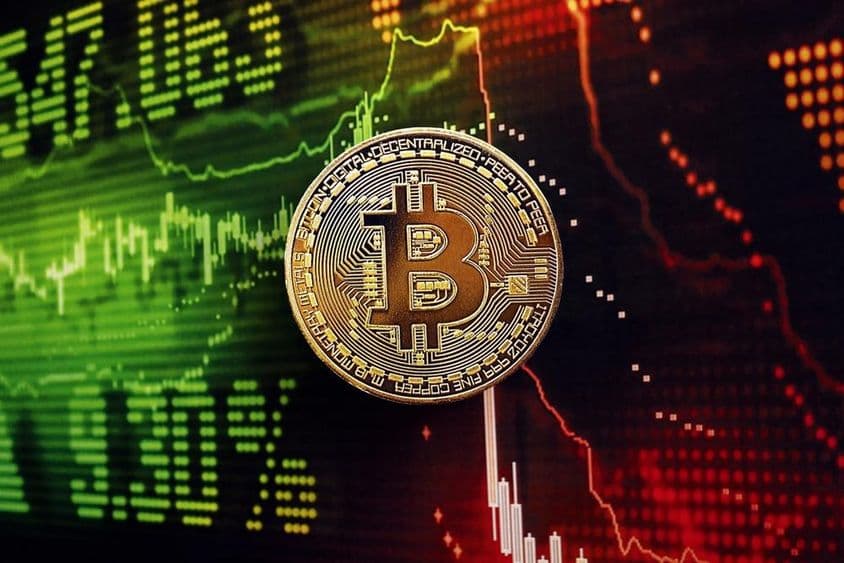 背后有股票市场图表的比特币硬币。