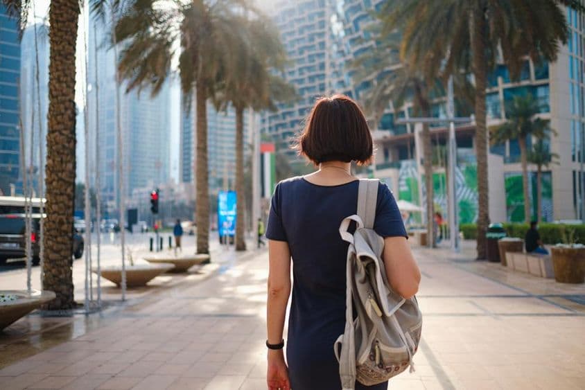 背着背包在迪拜步行的女子。