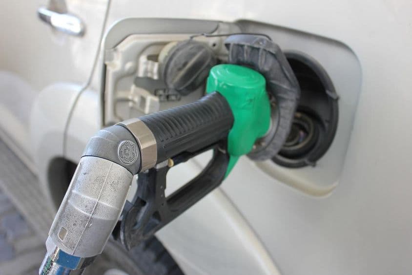 在加油站为一辆白色汽车加油。