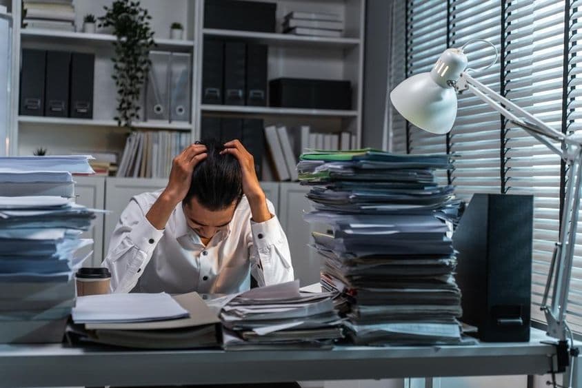 因工作负担过重而抱头的办公室职员。