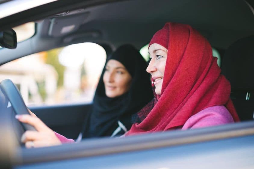 穆斯林女性开车,载着另一位穆斯林女性。