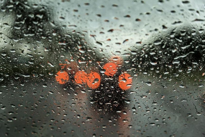 迪拜雨天,车窗上有雨滴,远处可见汽车灯光模糊。