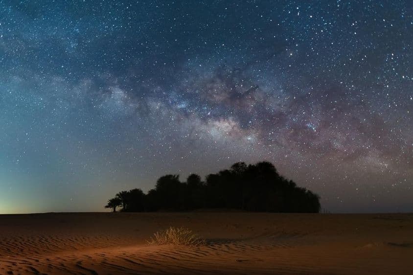 繁星点缀的牛奶般的天空覆盖着绿洲沙漠。
