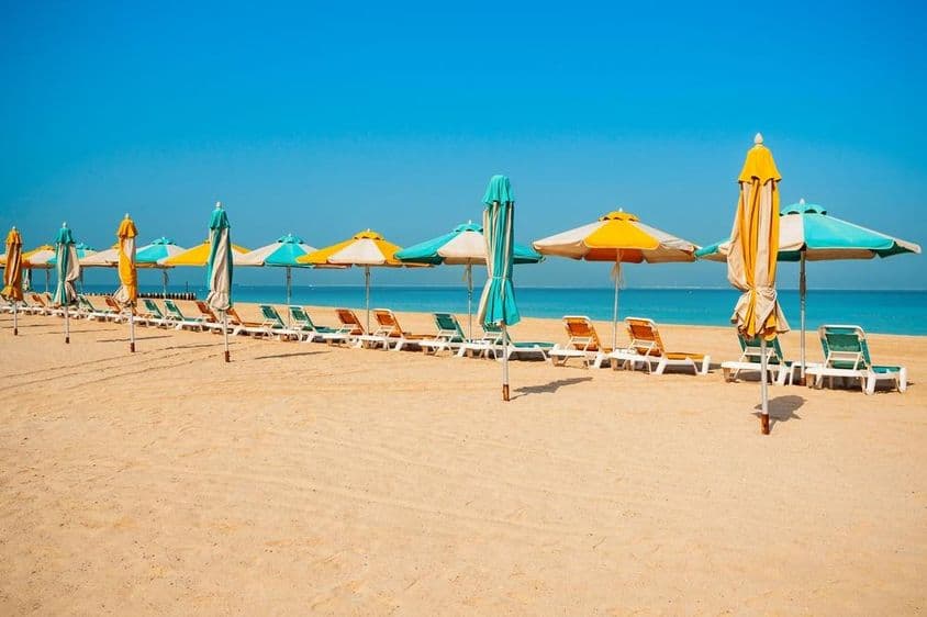 迪拜公共海滩,沙滩,日光浴椅和蓝色海洋。