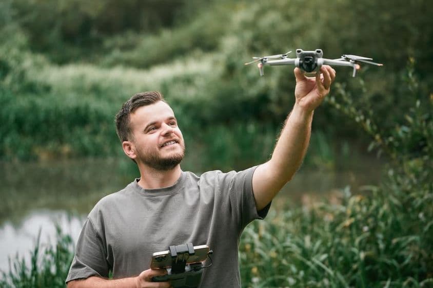 户外课堂上手持无人机的无人机教练。