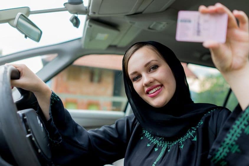 穆斯林女性驾驶汽车,手持驾照。