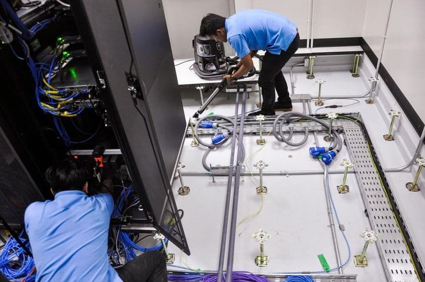 工人在建造一个服务器房间,抬高的地板和机架柜。