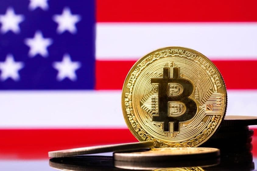 背景为美国国旗的金色比特币金属硬币。