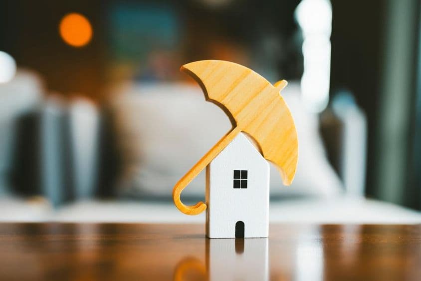 模型伞在木制小屋上,家庭保险。