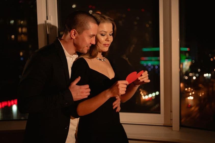 情人节约会中的一对情侣,站在窗边。