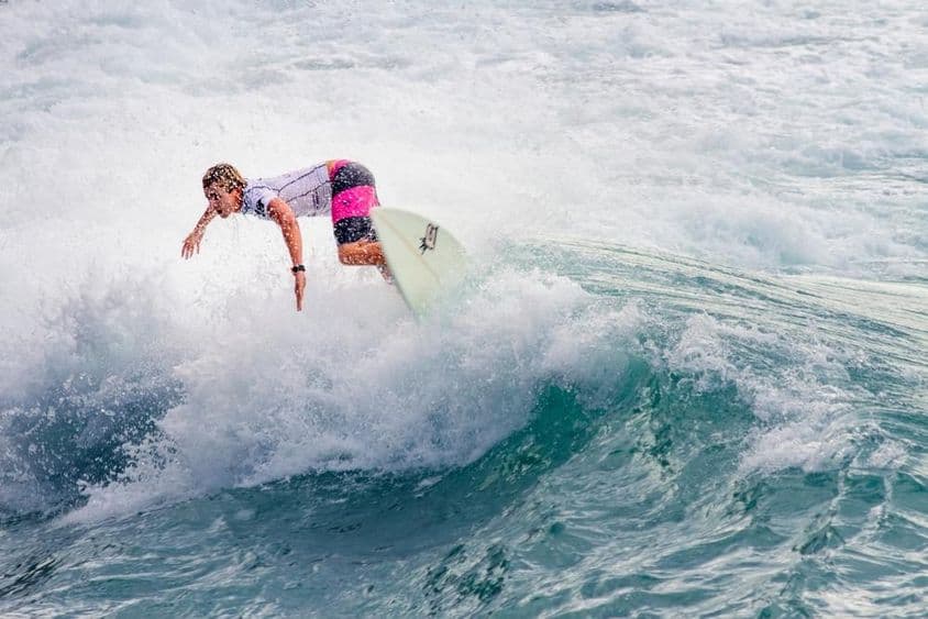 年轻小伙在大浪上冲浪。