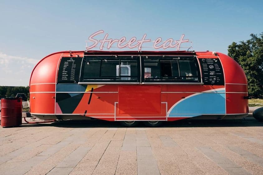 红色餐车,街道或广场上的快速食品销售场景。