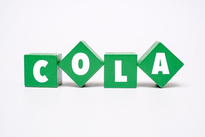 一个被涂成各种颜色的木块上写着 COLA。