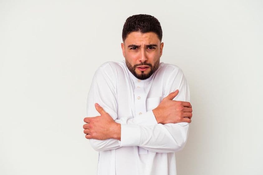 身着传统服饰的年轻阿拉伯男子因寒冷而颤抖。