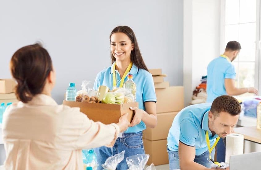 年轻的志愿者在慈善机构向需要帮助的人发放免费食物捐赠箱。