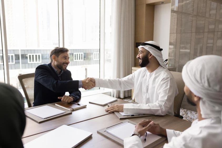 跨国商业伙伴通过握手完成成功谈判。