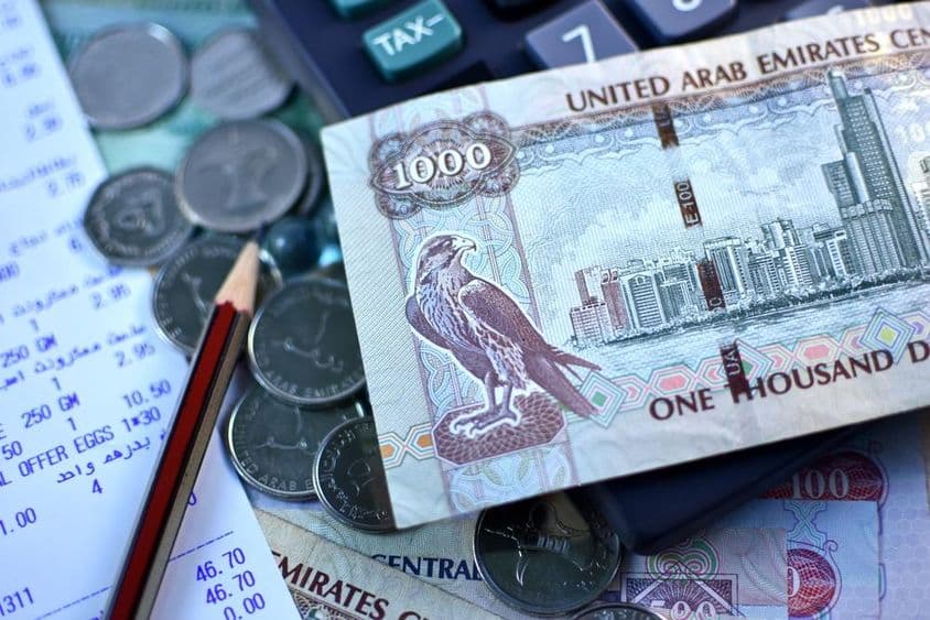 阿联酋1000迪拉姆钞票和一把硬币。