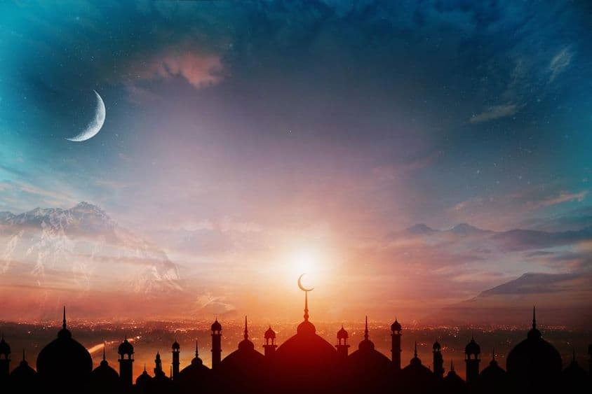 傍晚蓝天下,背景有新月的清真寺圆顶。