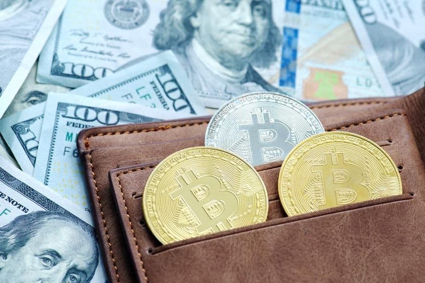 金色比特币和钱包,下面是美元纸币。