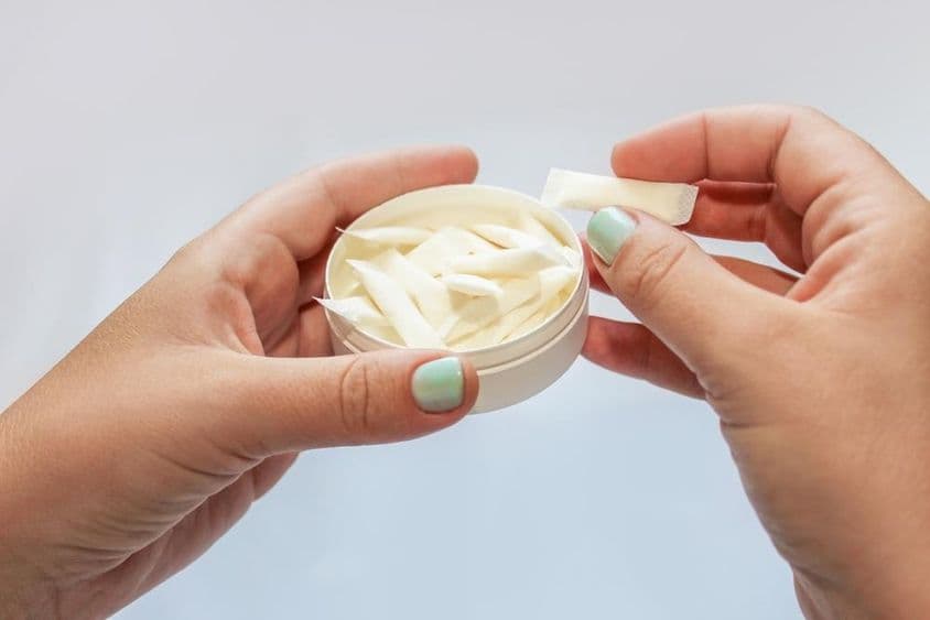 手中拿着鼻烟袋与尼古丁贴片。