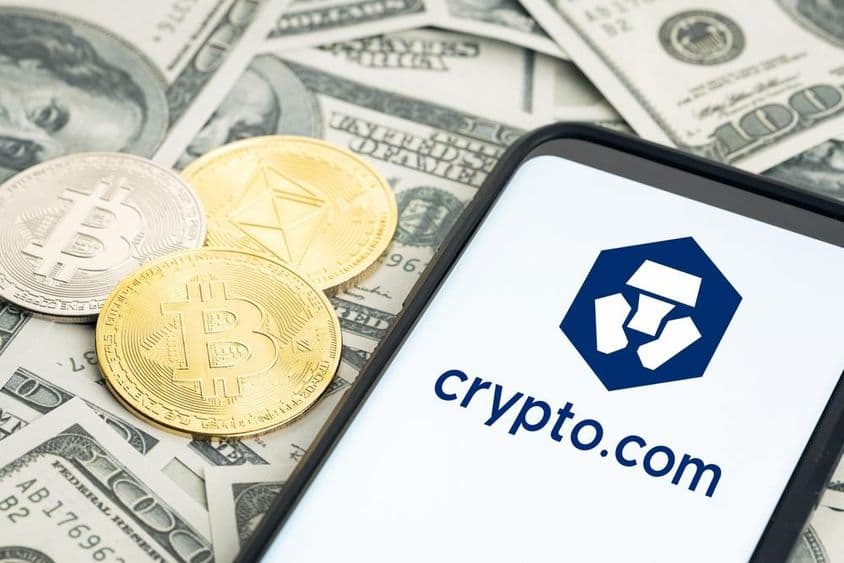 Crypto.com徽标,美元钞票,比特币和以太坊硬币可见。