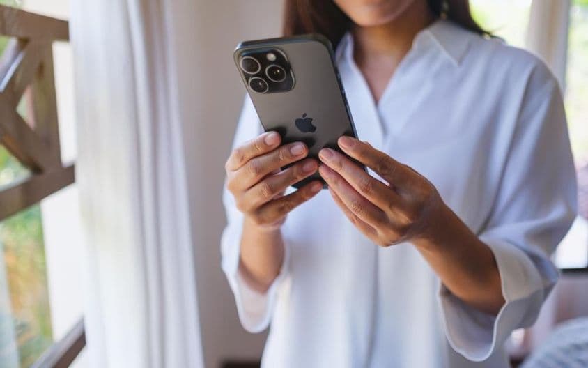 在家使用iPhone 15 Pro Max的女性。