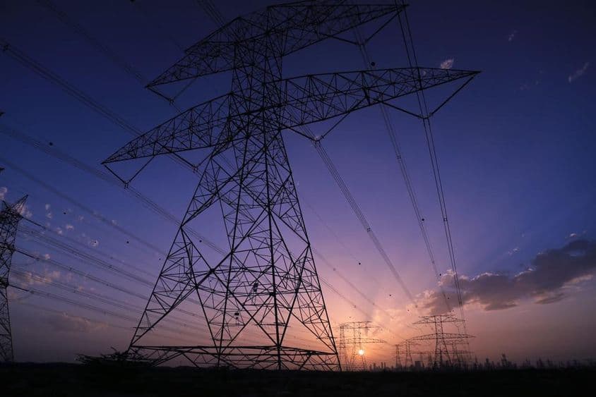 日落下的高压塔与迪拜城市景观