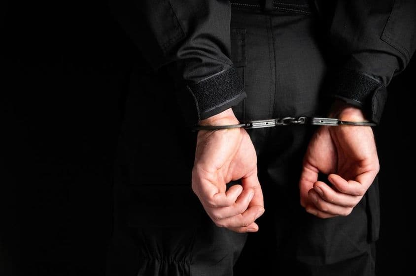 罪犯戴手铐的手。