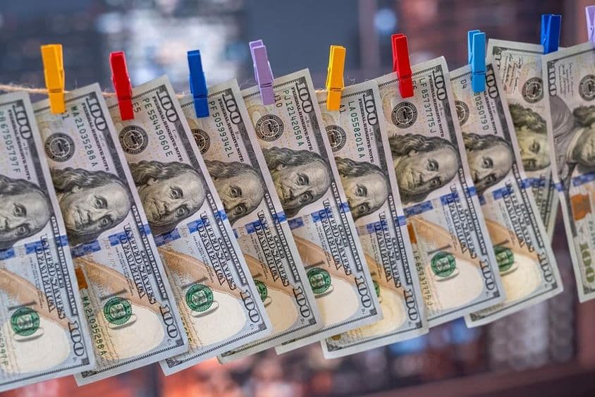 一张用木夹子挂在晾衣绳上的100美元钞票。