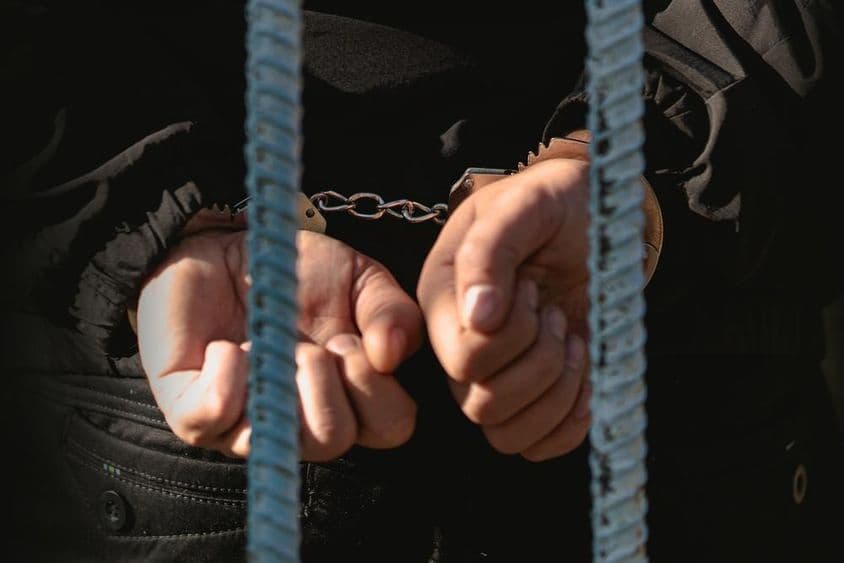在警察局内手铐束缚的囚犯。