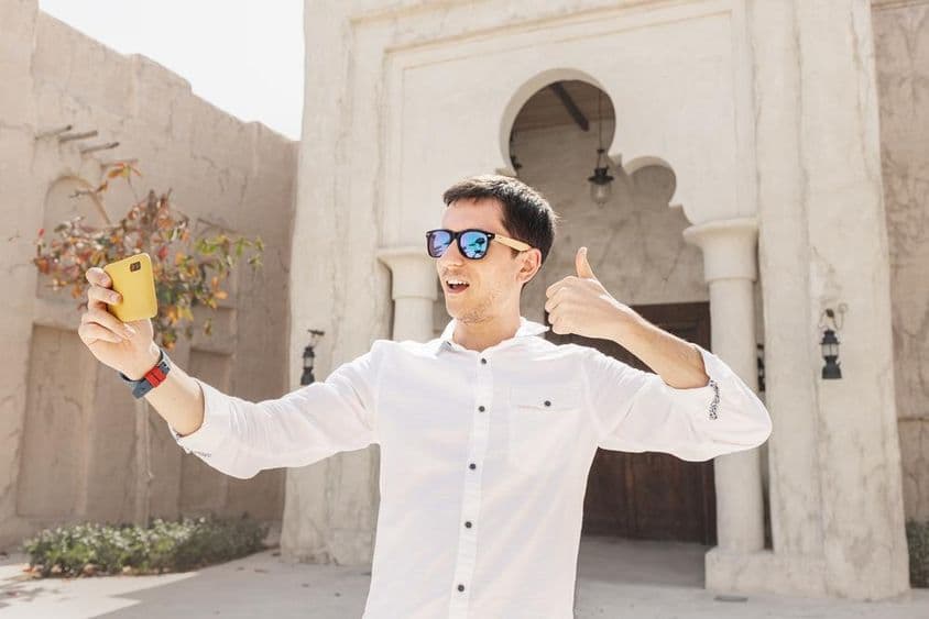 在旧迪拜河湾区录制视频博客的男子。