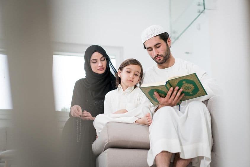 年轻的父母和一个小男孩在读书。