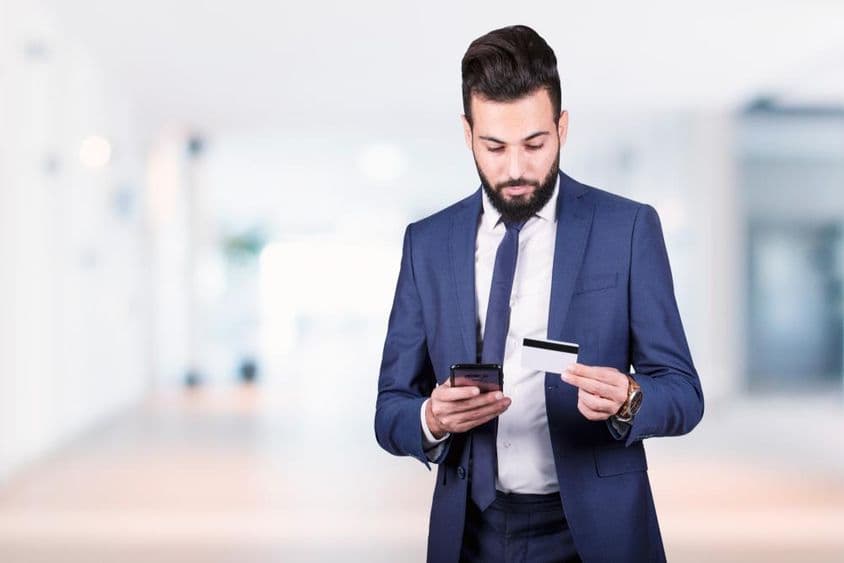 阿拉伯商人持手机和信用卡。