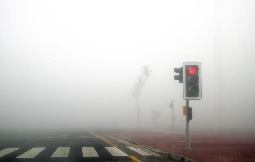 迪拜一条道路上的雾,红色信号灯闪烁。
