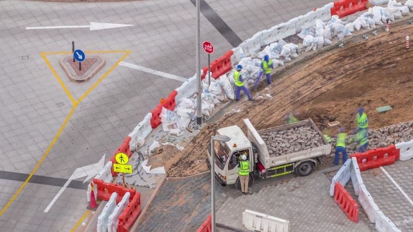 人行道维修过程,许多施工工人和设备正在打破人行道和混凝土。