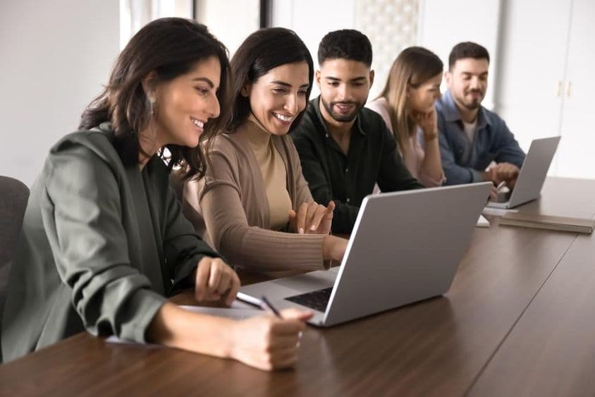 在教育中心学习的多国年轻成人学生使用笔记本电脑。