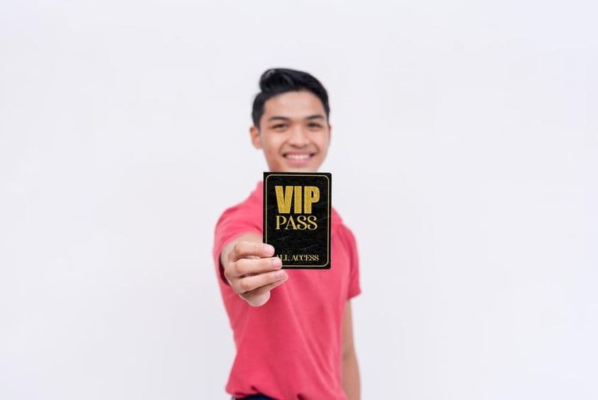 一位快乐的男士手持VIP票或徽章。