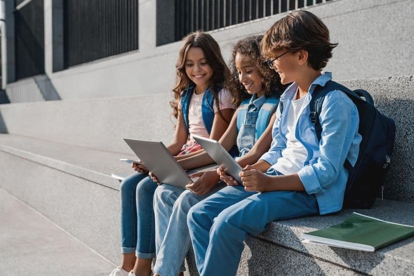 幸福的学生们,少年们使用平板电脑。