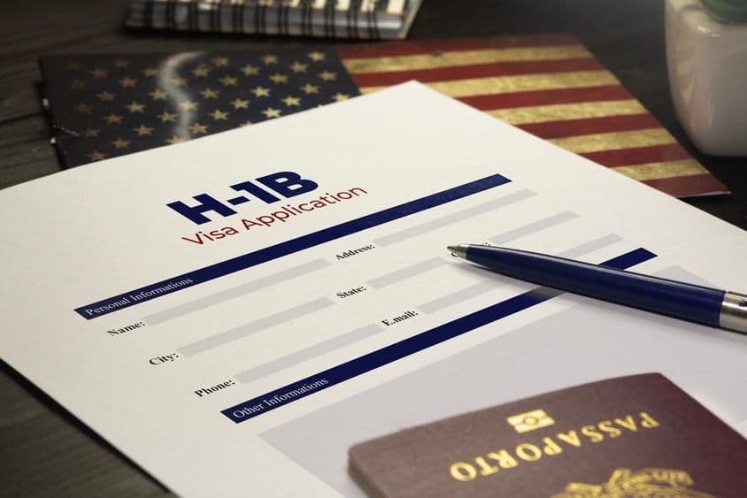 H-1B签证申请放置在桌上,旁边有护照。