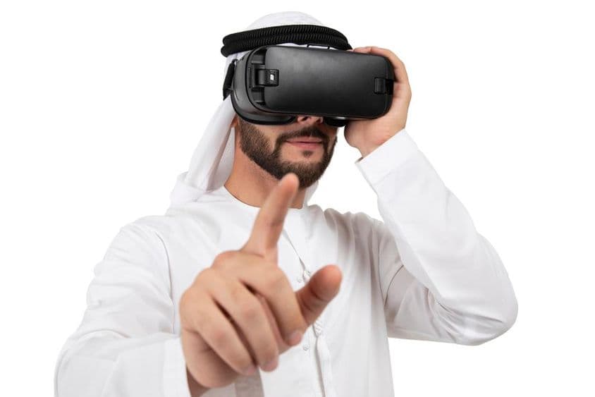 身穿阿拉伯服装的男子在VR头盔中做手势。