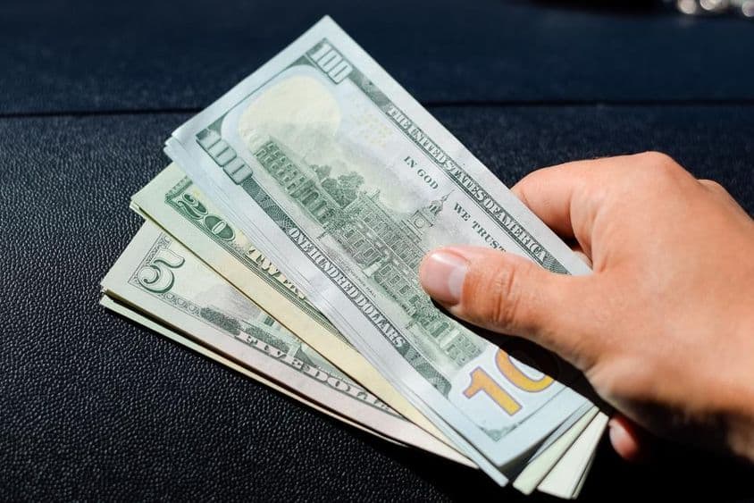 一个男人手中的一沓美元。