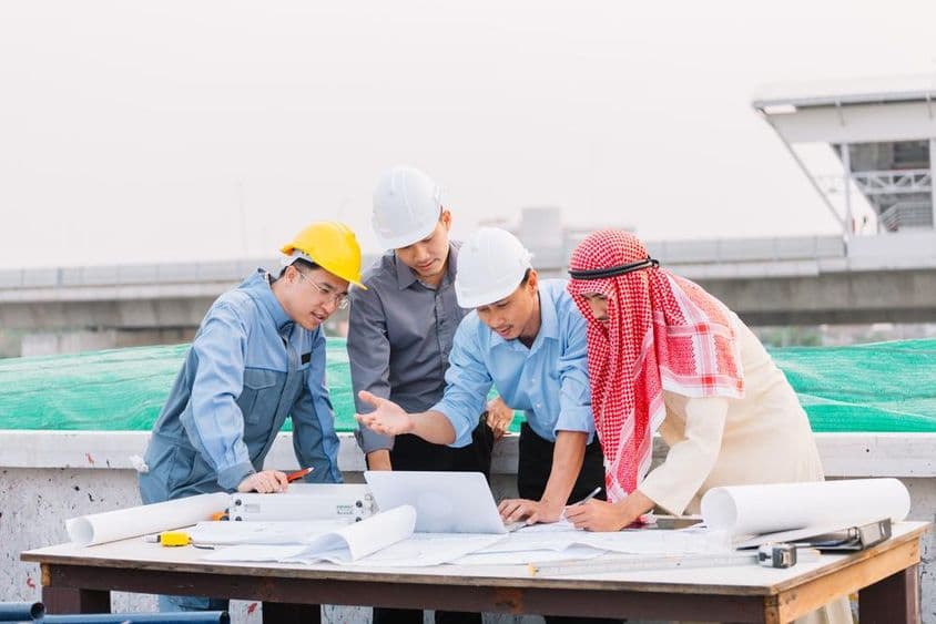 阿拉伯商人、工程师和工人利用笔记本电脑讨论施工计划。