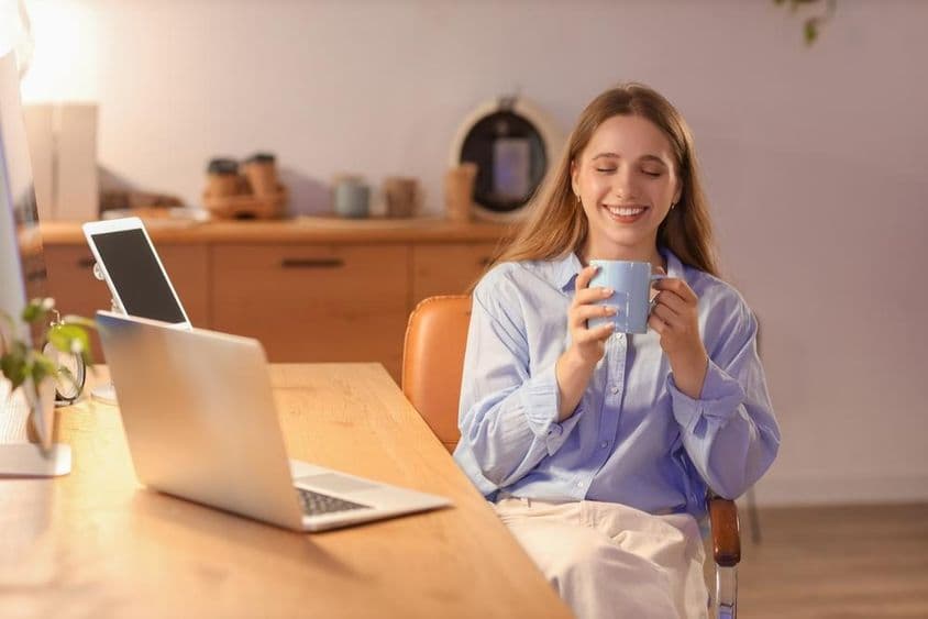 年轻的女商人在晚上于办公室喝咖啡。