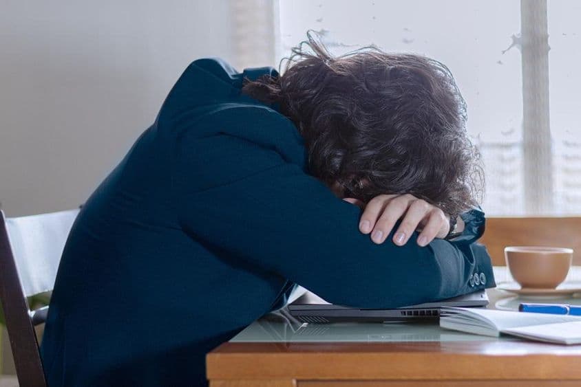 周一在工作时趴在笔记本上的人。